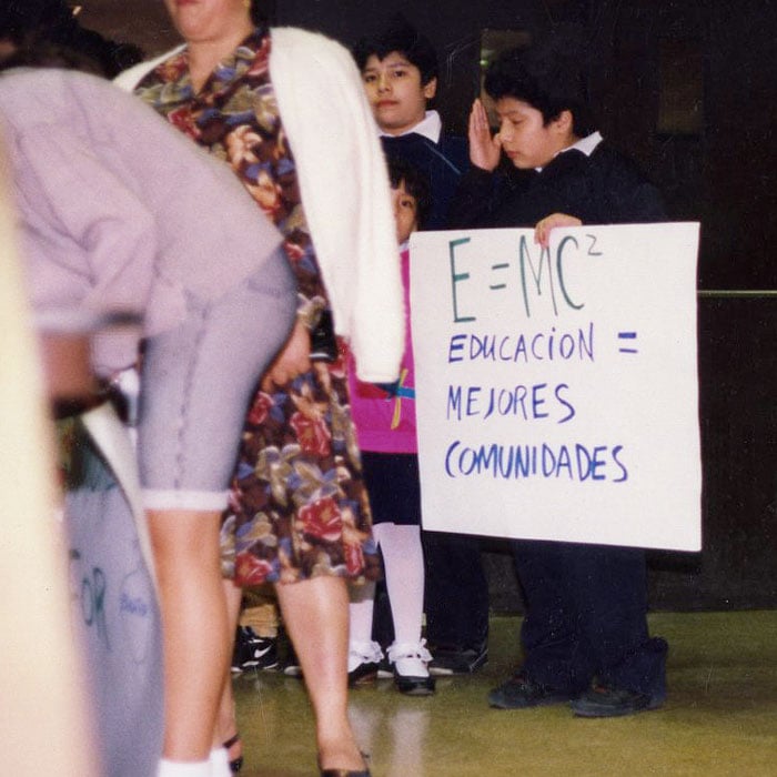 A young child holds a sign in protest.