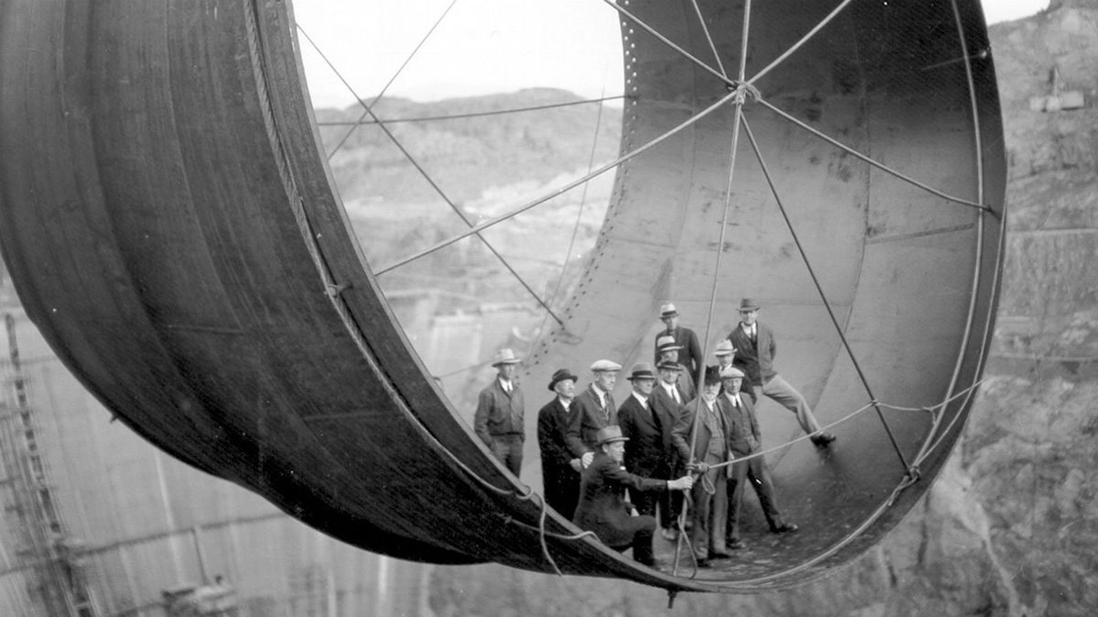 Officials ride in one of the penstock pipes of the soon-to-be-completed Hoover Dam