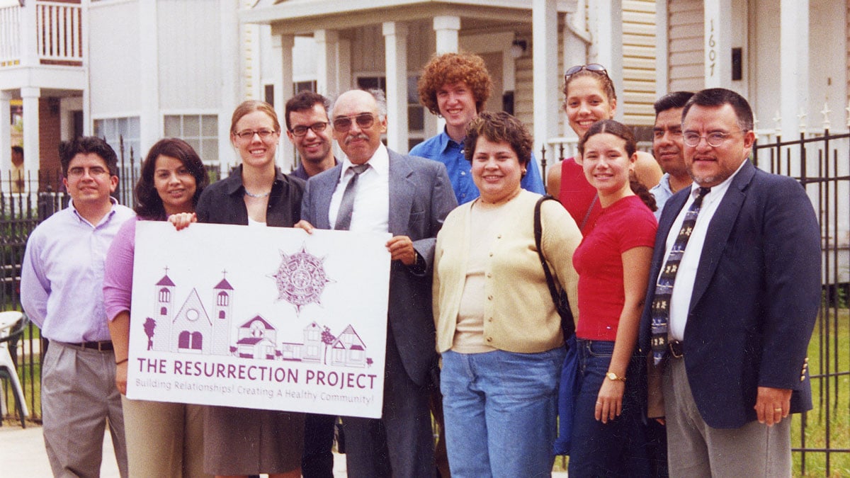 The Resurrection Project team stands in front of the new houses on Throop.