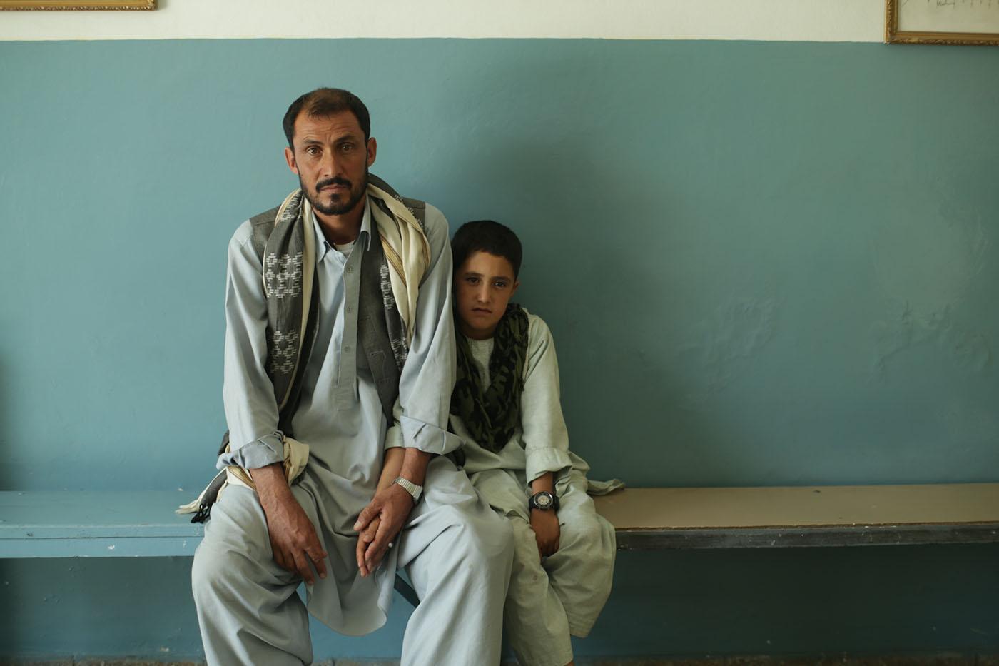 An Afghan survivor of a U.S. air strike with his son. Photo: Torsten Lapp