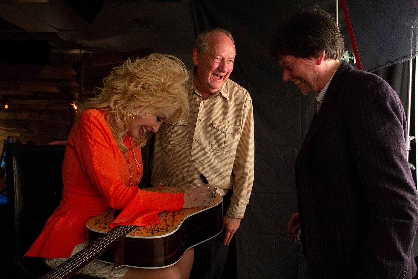 Dolly Parton signs a Martin D-28 guitar, with Dayton Duncan and Ken Burns, after being interviewed for 'Country Music.' Photo: Katy Haas