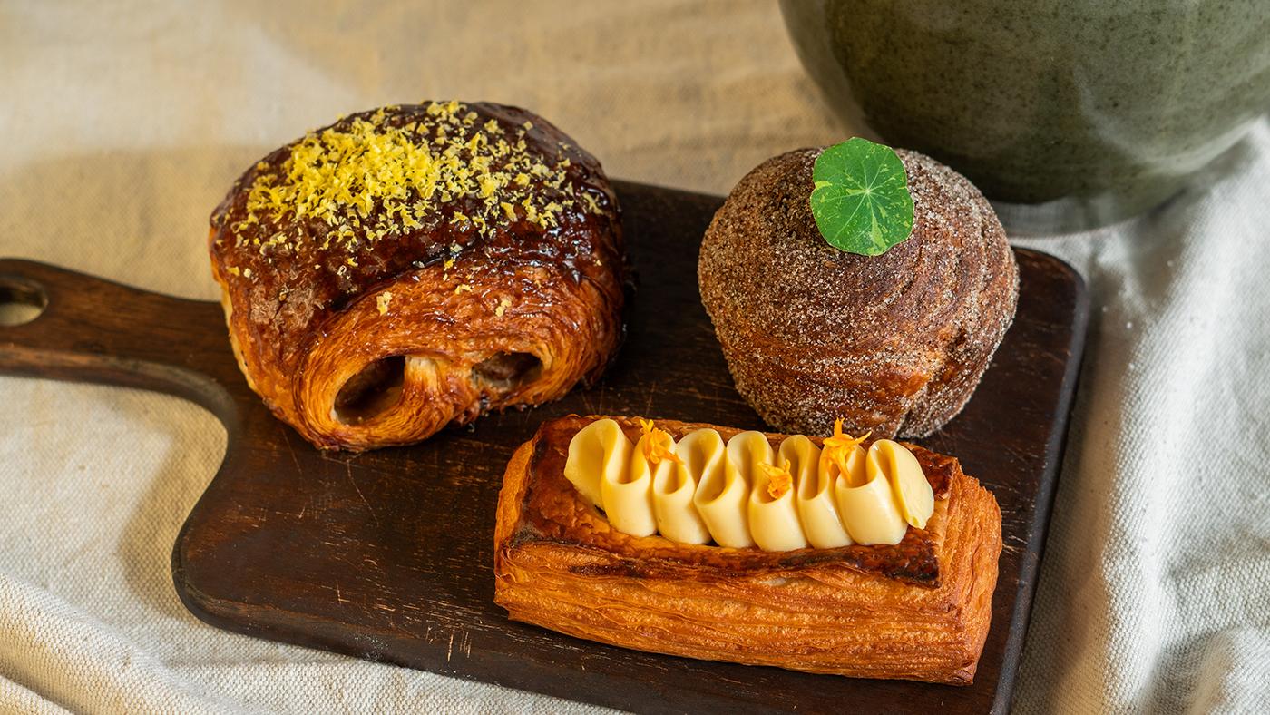 Three pastries on a cutting board on a cloth