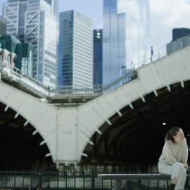 Alice and Jack sit in front of two large tunnels and some skyscrapers