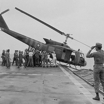 U.S. Navy personnel push a helicopter into the sea to make room for more evacuation flights from Saigon. April 29, 1975. Photo: AP/Jacques Tonnaire