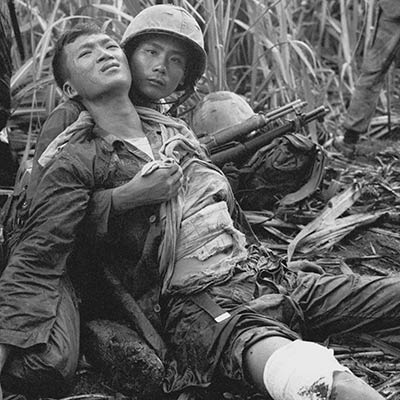 South Vietnamese soldier comforts severely wounded comrade. Near Saigon. August 5, 1963. Photo: AP/Horst Faas