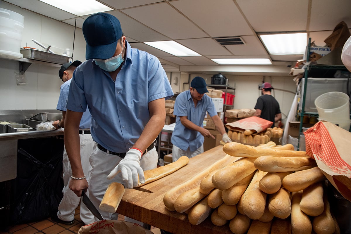  One of the first activities is pre-cutting the French bread into 6-inch slices for the sandwiches.