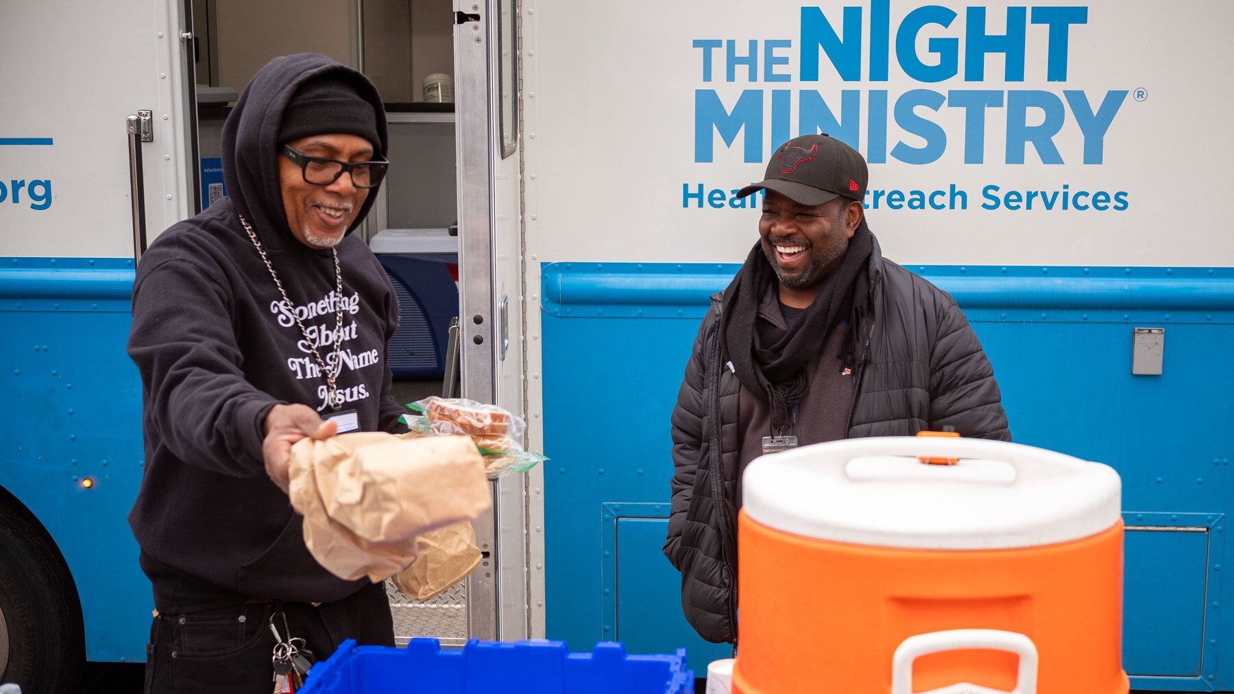 Edward O. Davis and Sylvester Farmer restock to-go meals outside the Night Ministry truck in Garfield Park.