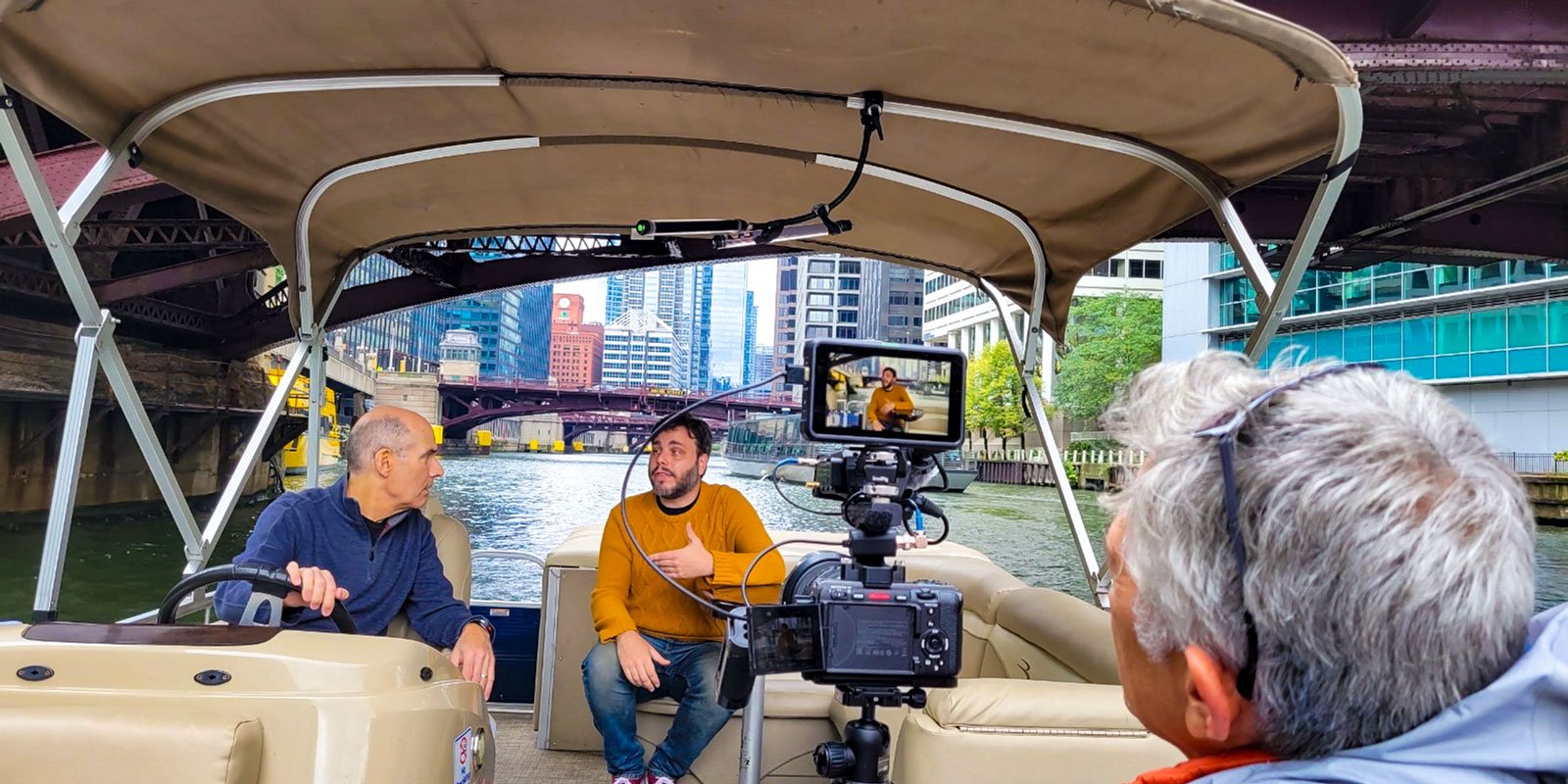 Oral User, right, films Mark Chrisler and Geoffrey Baer on the Chicago River.