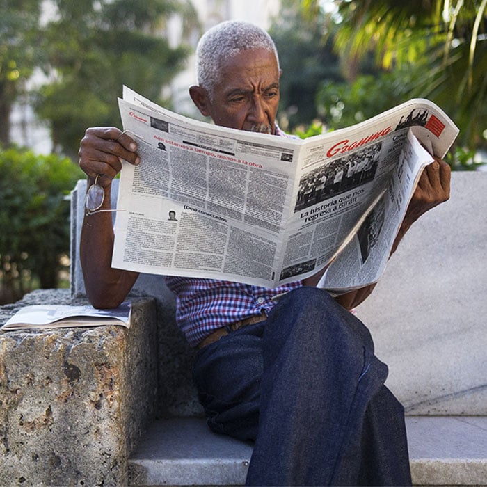 Man in Parque Central reading Granma in Havana