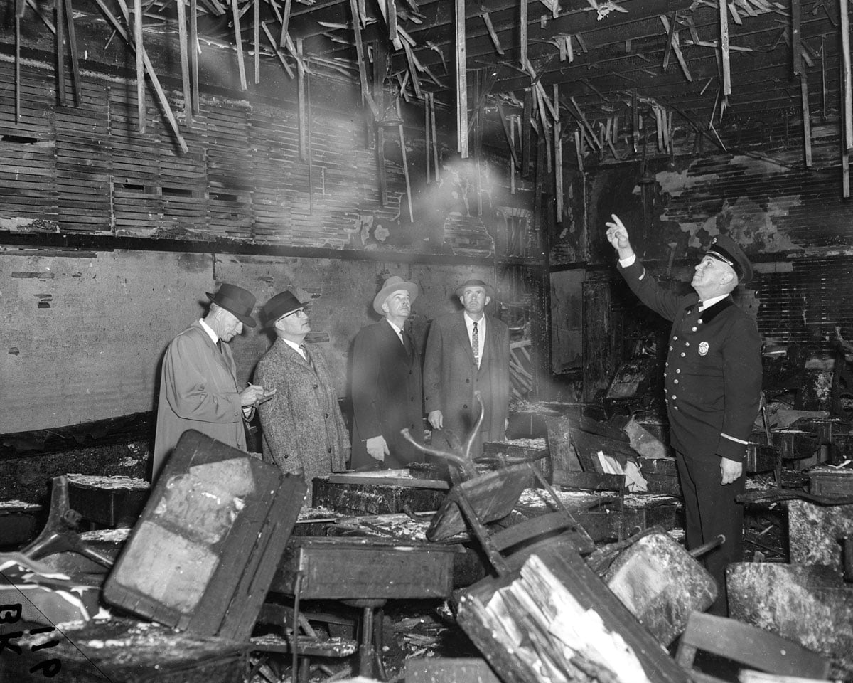 Men assessing damage in a burned room