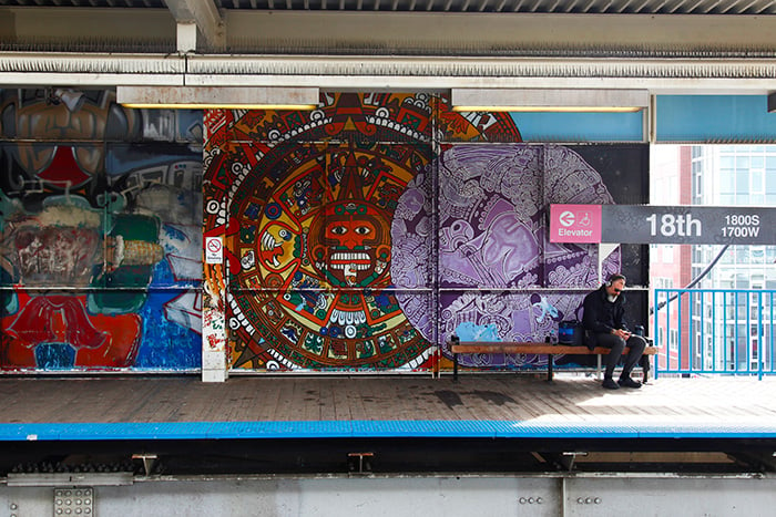 A commuter waits on the train on the 18th Street Pink Line platform