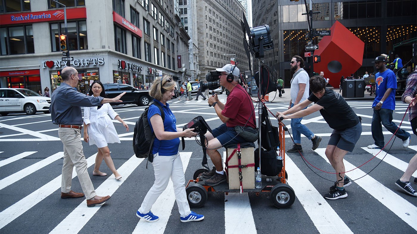 Director of Photography Tim Boyd and the camera crew record Geoffrey Baer talking with Michelle Young while crossing Broadway in New York City in August 2017