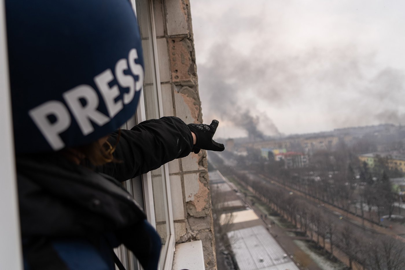 Photographer Evgeniy Maloletka points at the smoke rising after an airstrike on a maternity hospital in Mariupol, Ukraine, March 9, 2022. Still from FRONTLINE PBS and AP’s feature film “20 Days in Mariupol.” Credit: AP Photo/Mstyslav Chernov)