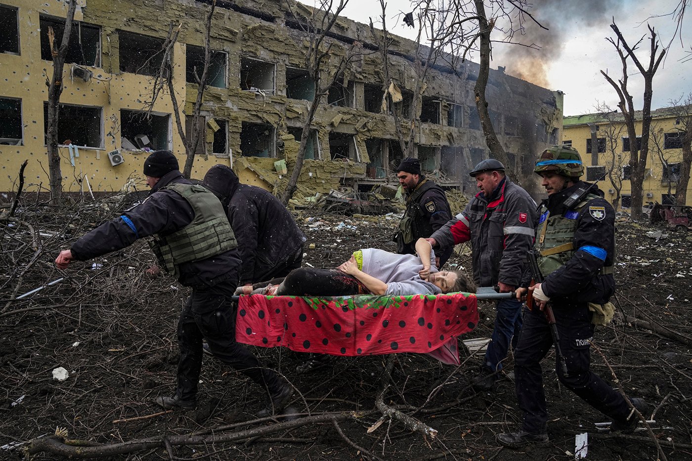 Ukrainian emergency workers and volunteers carry an injured pregnant woman from a maternity hospital damaged by an airstrike in Mariupol, Ukraine, March 9, 2022. The woman was taken to another hospital but did not survive. Still from FRONTLINE PBS and AP’s feature film “20 Days in Mariupol.” Credit: AP Photo/Evgeniy Maloletka