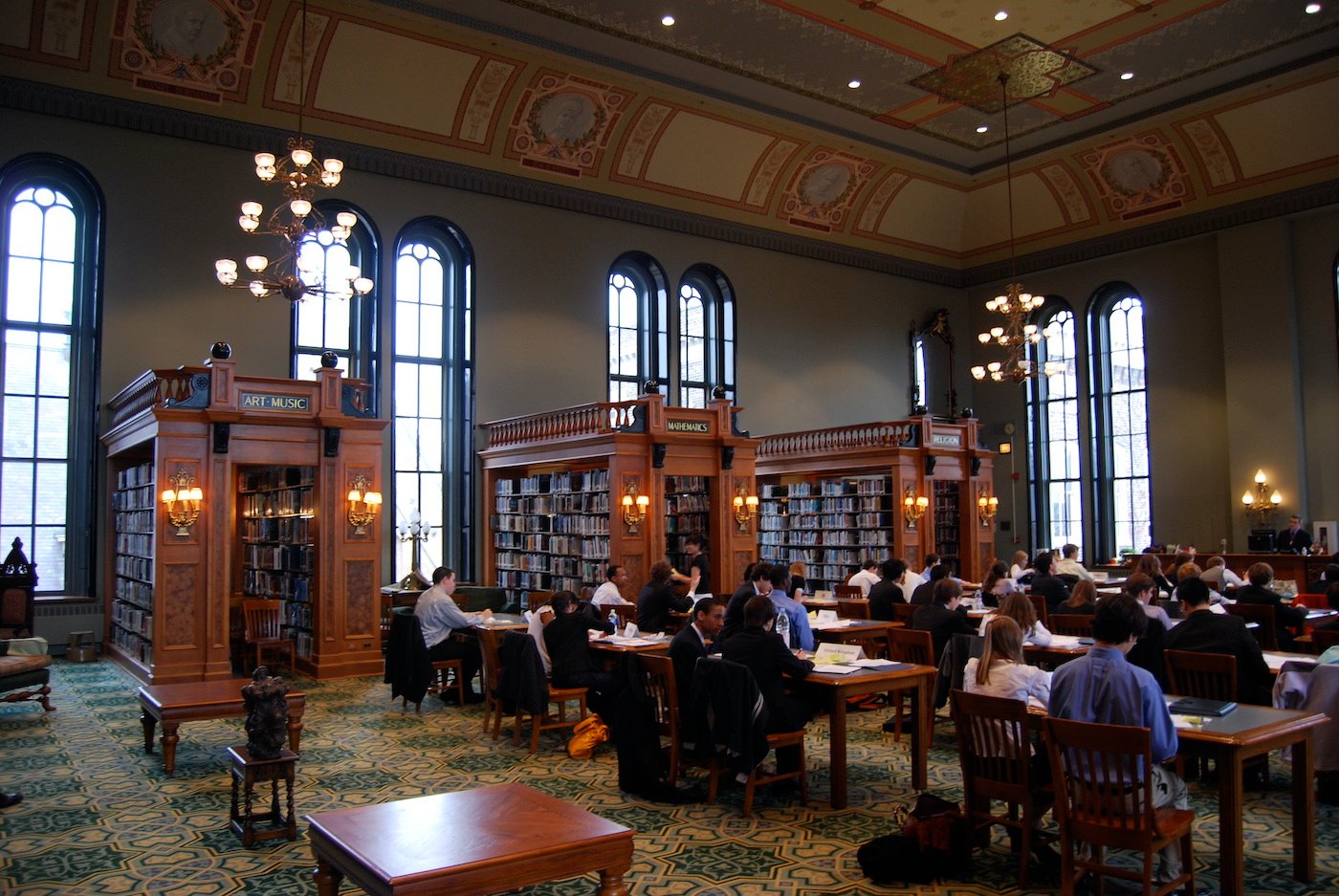 Students hosting Model UN at Foglia Library inside St. Ignatius College Prep in Chicago. Arts, music, mathematics, and religion book stacks visible in background.