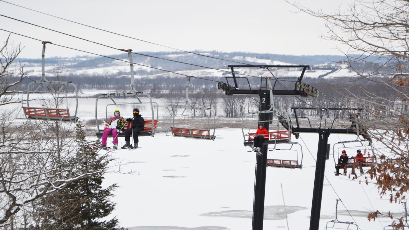 Skiers (including Geoffrey Baer in the red jacket) ride the lift at Chestnut Mountain