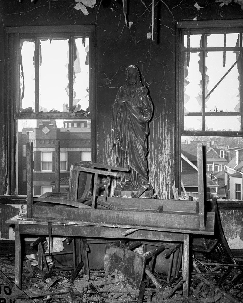 A statue of Jesus is left badly charred in the aftermath of the fire
