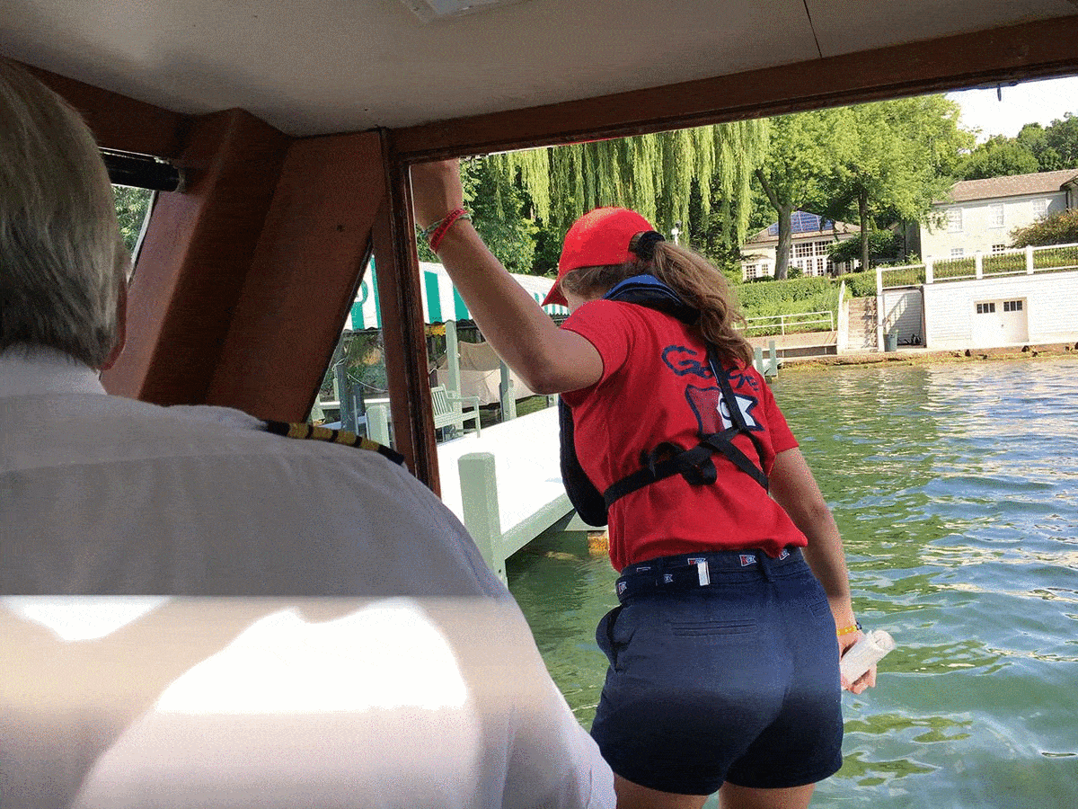 Molly McEneany leaps onto residential docks to deliver the mail in Lake Geneva in August 2018 