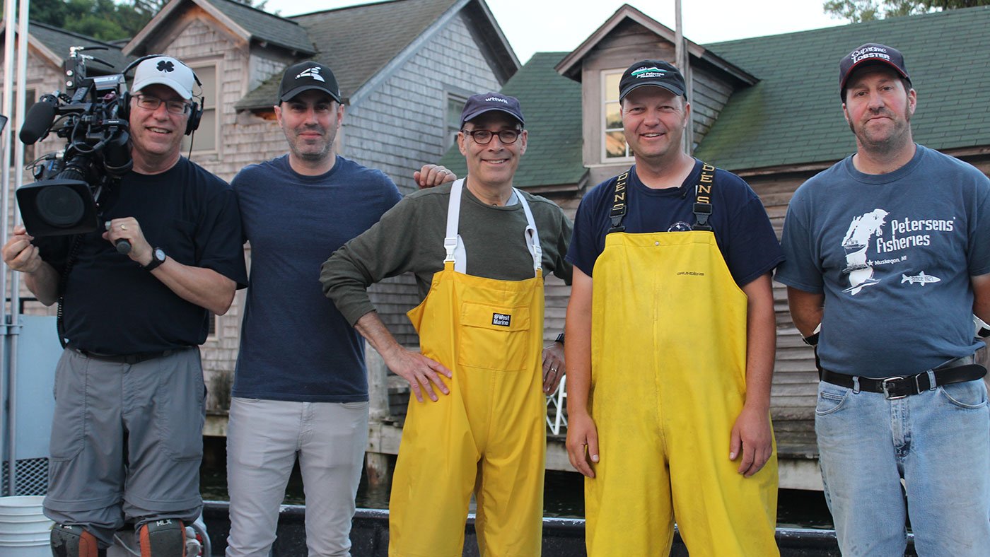 WTTW camera crew posing with commercial fishermen in Leland, Michigan's Fishtown