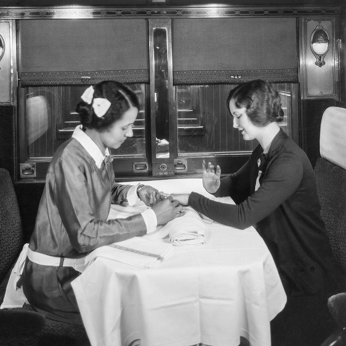 Black Pullman maid giving a manicure to a passenger