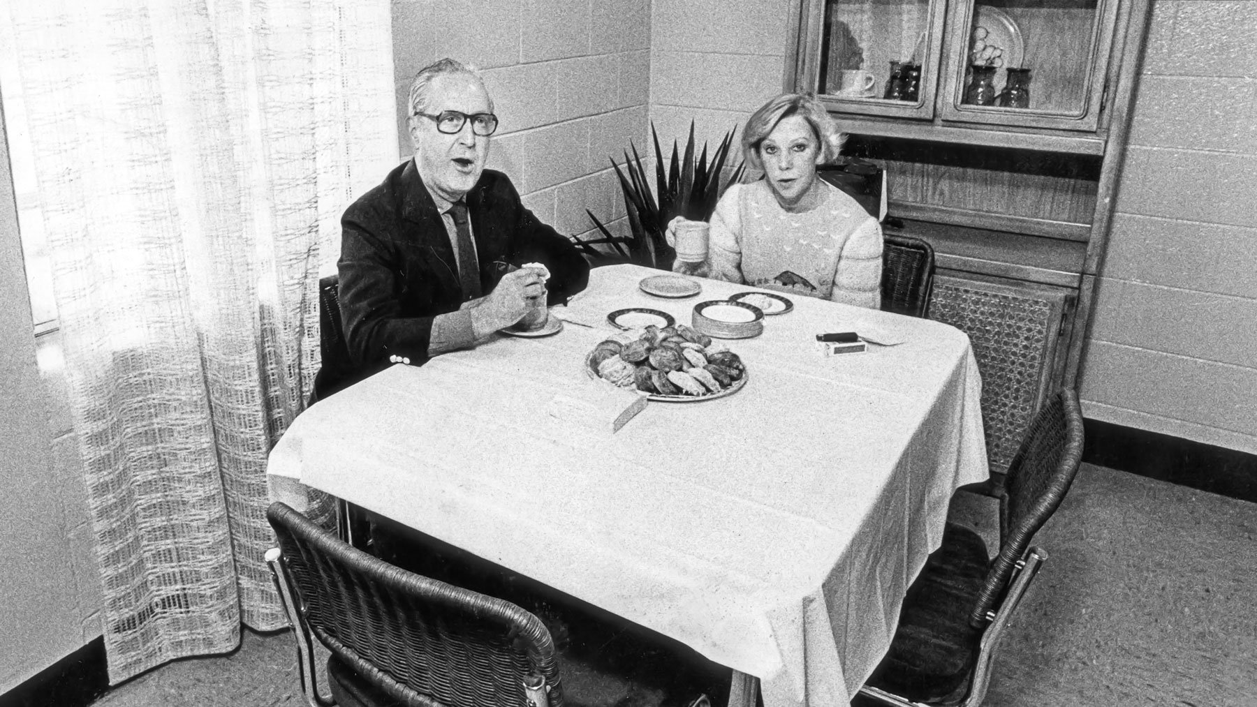 Jane Byrne and her husband sitting at table with food