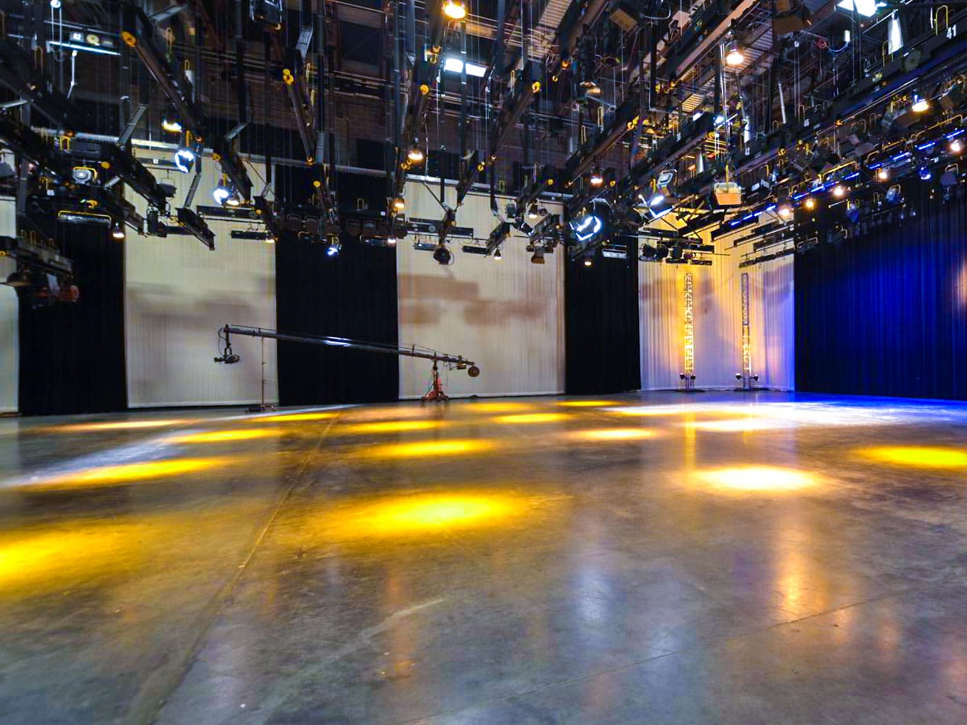 Large empty studio with lighting grid and concrete floors