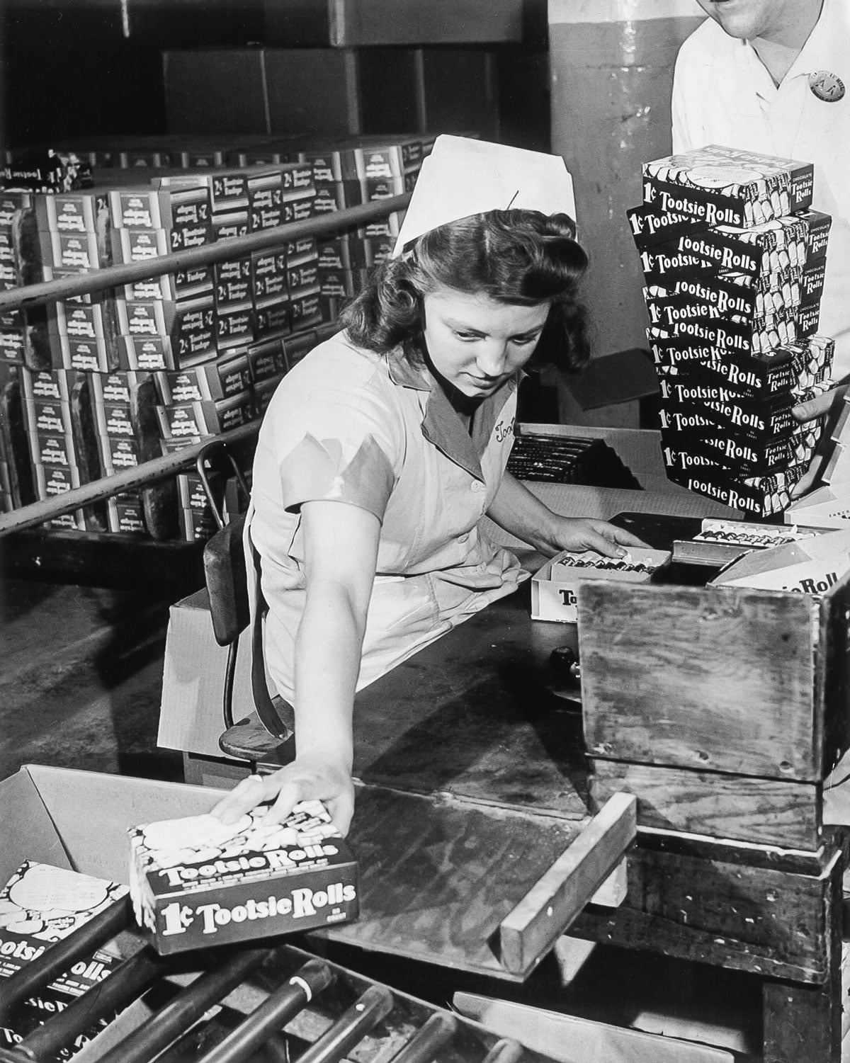 Woman packaging Tootsie Rolls in boxes