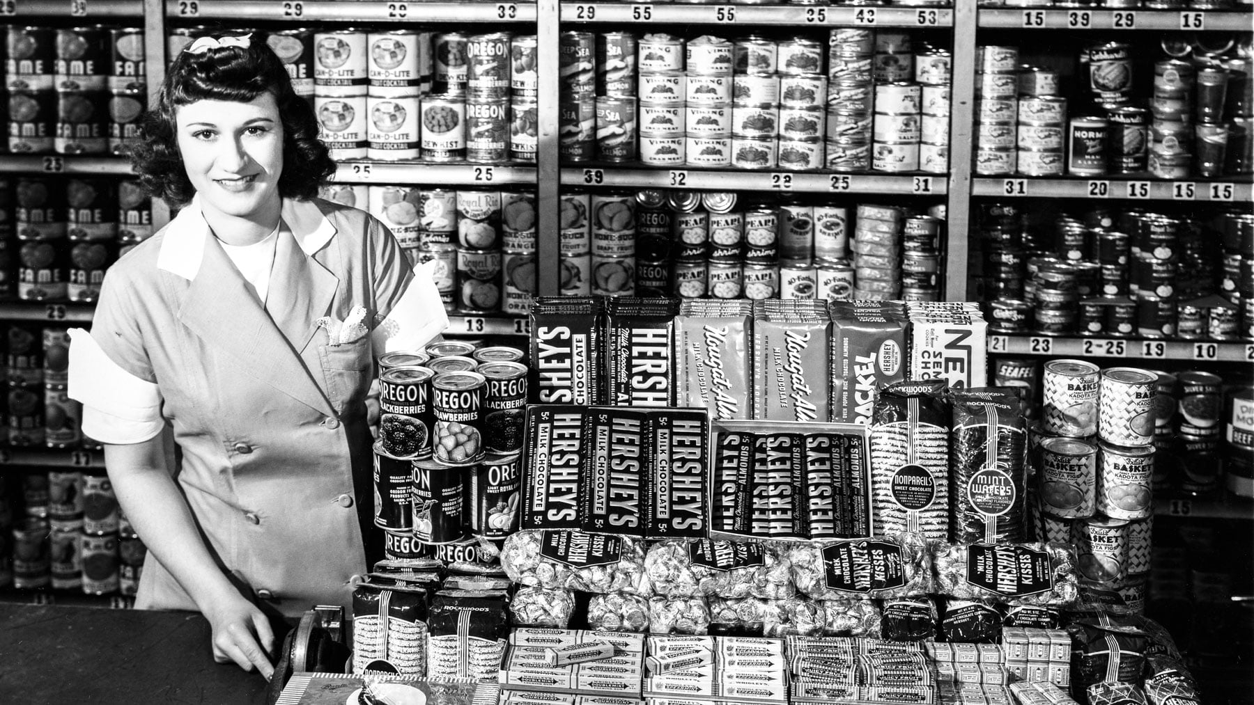 A woman stands with the candy display at Isabelle’s Restaurant in 1941