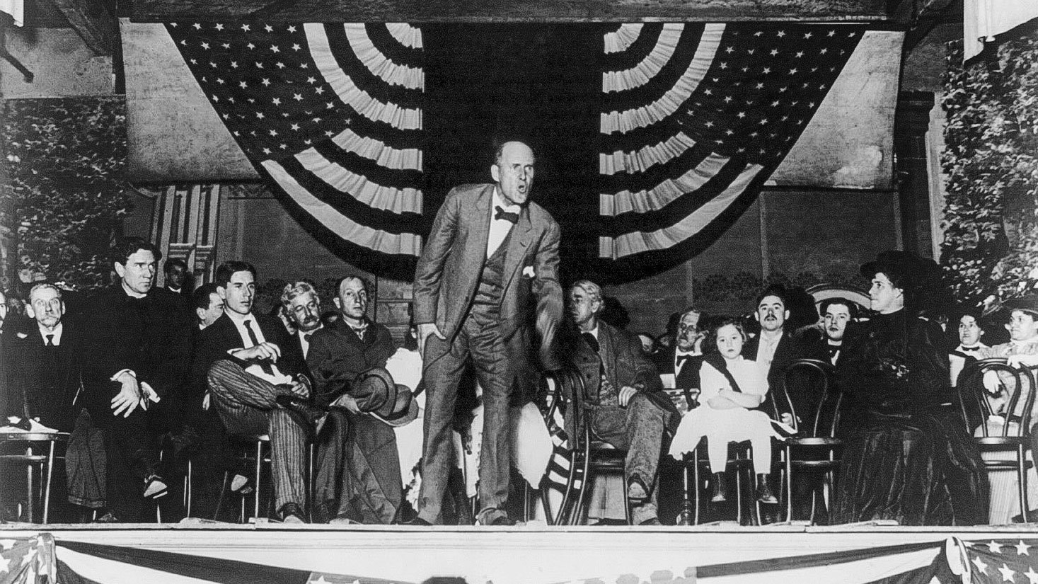 Eugene Debs giving a speech on a stage