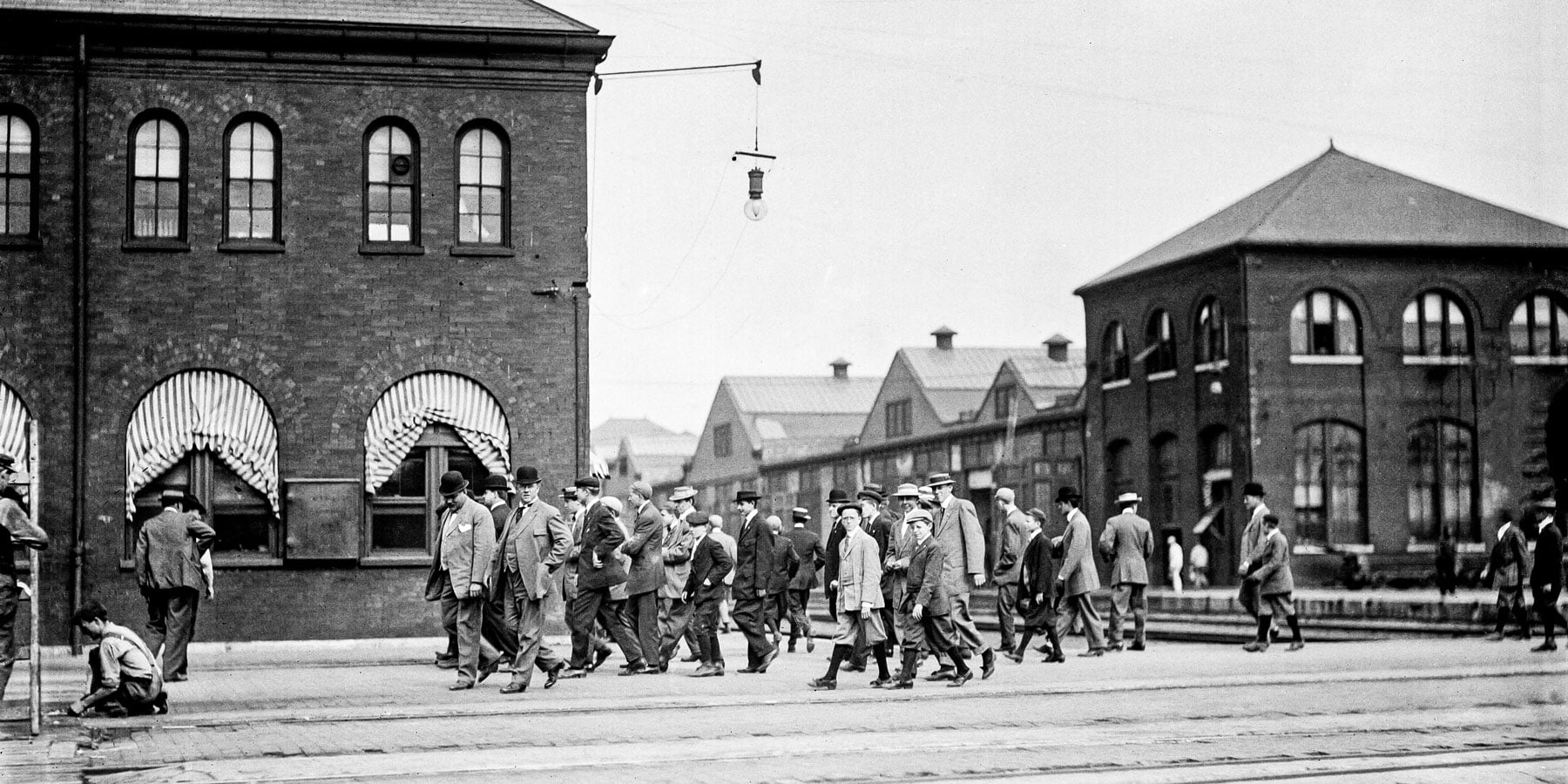 A group of men and boys walking along a street in Pullman in 1909