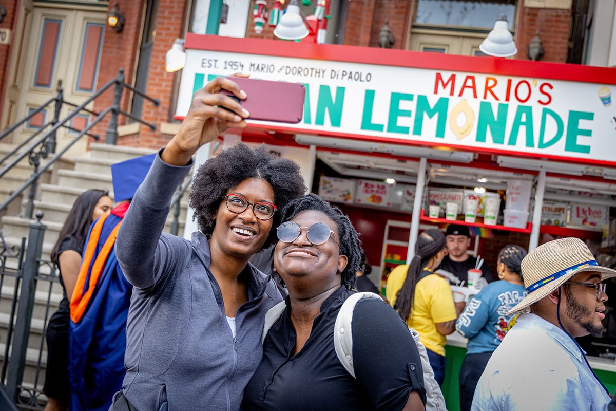 Two women taking a selfie in front of Mario’s Italian Lemonade stand.