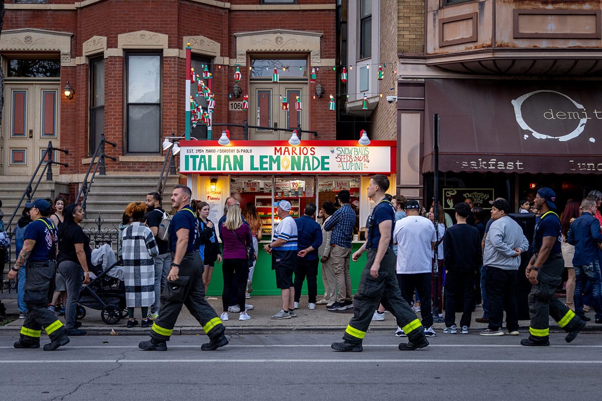 Firefighters walk to the end of the line of the Italian Lemonade stand.