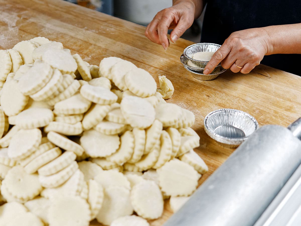 Stacks of cut out dough and small pie tins
