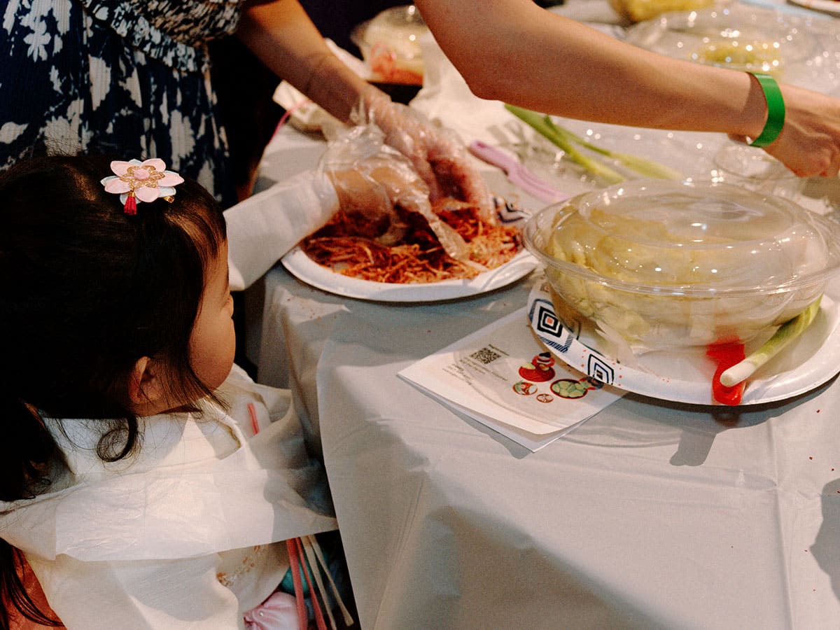 A small child helps to mix the ingredients with her hand