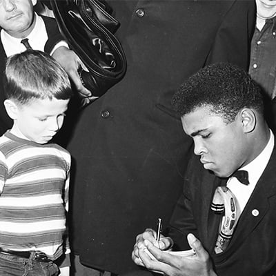 Boxer Muhammad Ali signs an autograph for five year-old Tony Barton on March 13, 1964. Photo: ST-50000443-0001, Chicago Sun-Times collection, Chicago History Museum