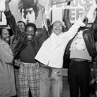 Fans cheer for Muhammad Ali after his victory over George Foreman in Zaire. The fight was broadcast in a theater for fans to watch in Chicago, Illinois on October 29, 1974. Photo: ST-20003241-0016, Chicago Sun-Times collection, Chicago History Museum