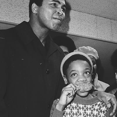 Muhammad Ali attending the opening celebration of his fast-food restaurant, Ali's Trolley, at 5064 South State Street. Chicago, Illinois, December 8, 1975. Photo: ST-19130563-0013, Chicago Sun-Times collection, Chicago History Museum