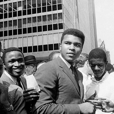 Muhammad Ali, is surrounded by autograph seekers at 51st Street and Sixth Avenue in Manhattan, New York. August 23, 1968. Photo: Courtesy of AP Images