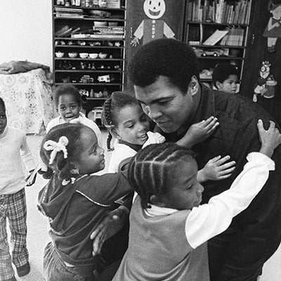 Muhammad Ali on a visit to his old grammar school surrounded by students. Louisville, KY. Circa 1977. Photo: Courtesy of Michael Gaffney
