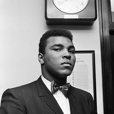 Boxer Muhammad Ali stands under a clock waiting on a hearing with the Illinois Athletic Commission on February 25, 1966 over whether to cancel his fight against Ernie Terrell for Ali’s refusal to serve in the military. Photo: ST-50000449-0001, Chicago Sun-Times collection, Chicago History Museum