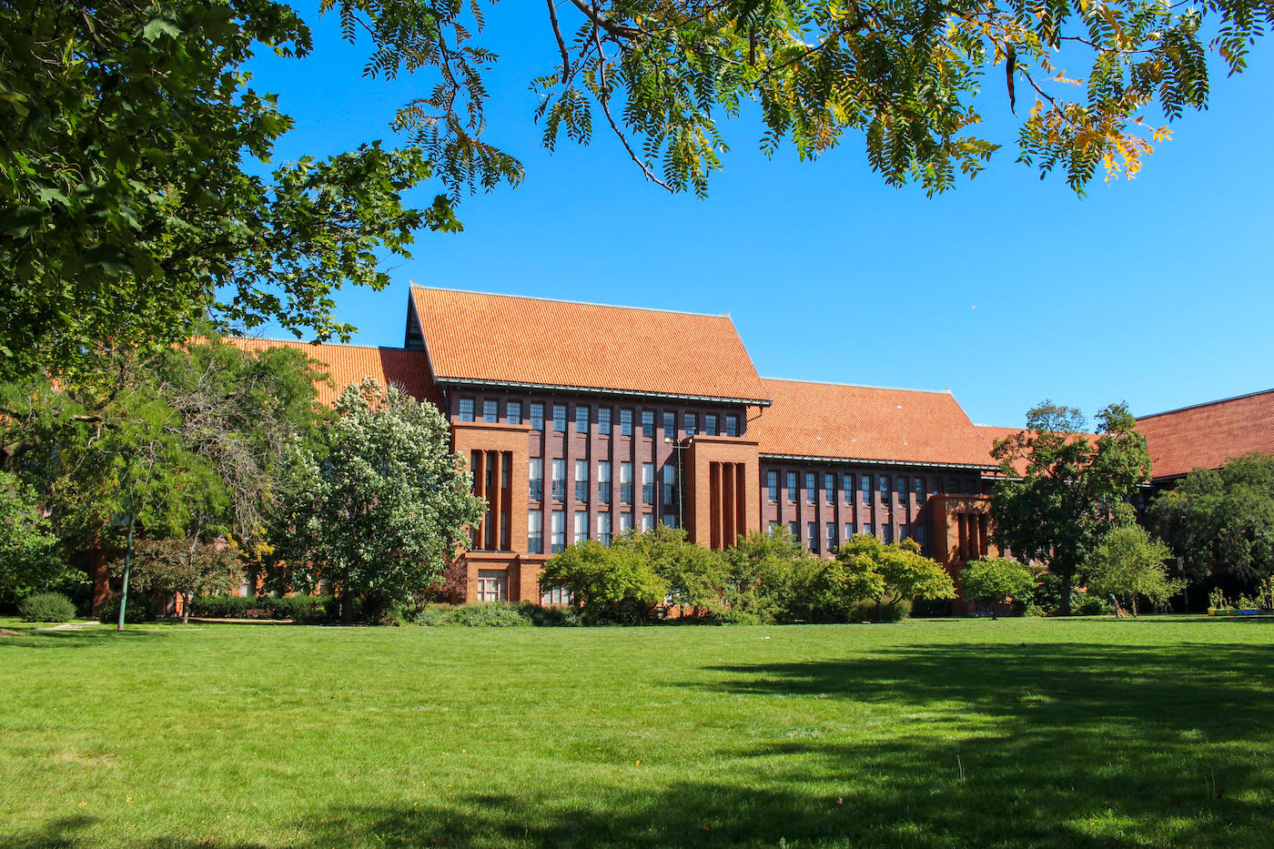 The orange-roofed Schurz high school seen across a lawn against a blue sky