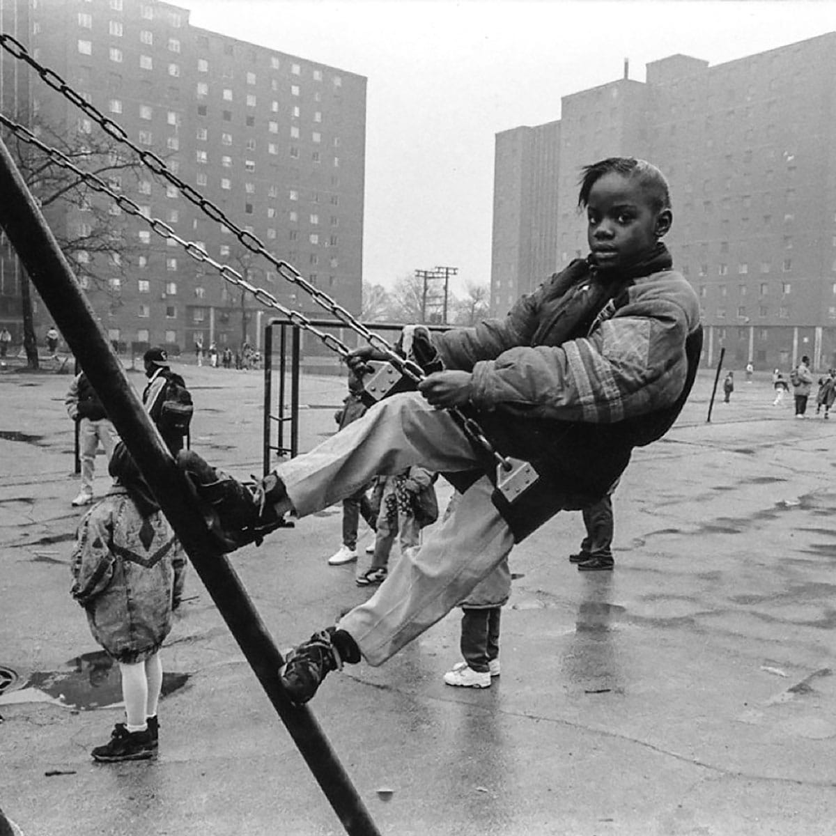 Child on swing in foreground with other people in background