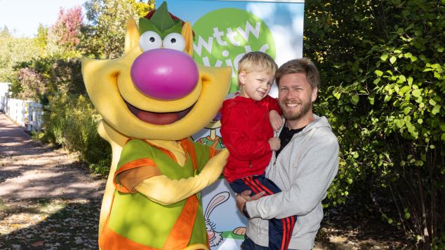 Nature Cat posing with toddler held by father