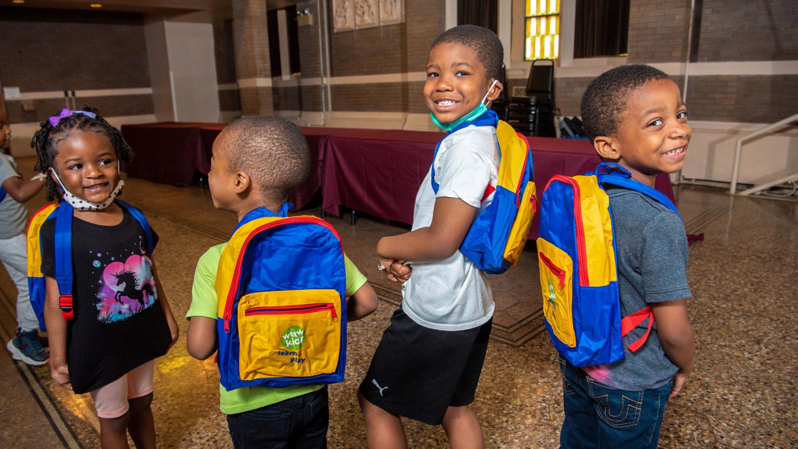 Four excited preschool-age children with WTTW Kids Learn & Play backpacks