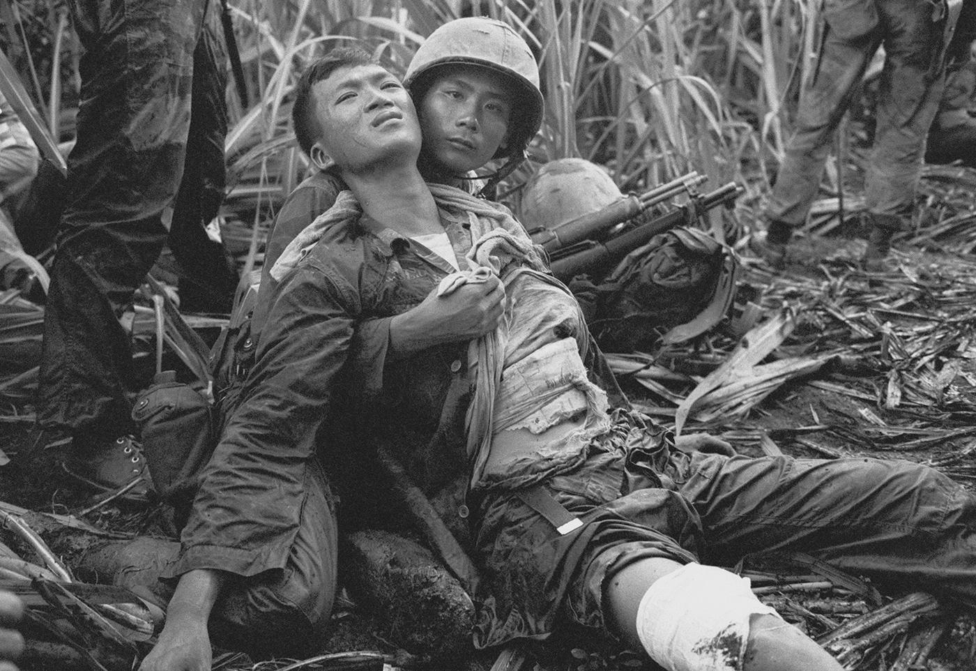 South Vietnamese soldier comforts severely wounded comrade. Near Saigon. August 5, 1963. Photo: AP/Horst Faas 