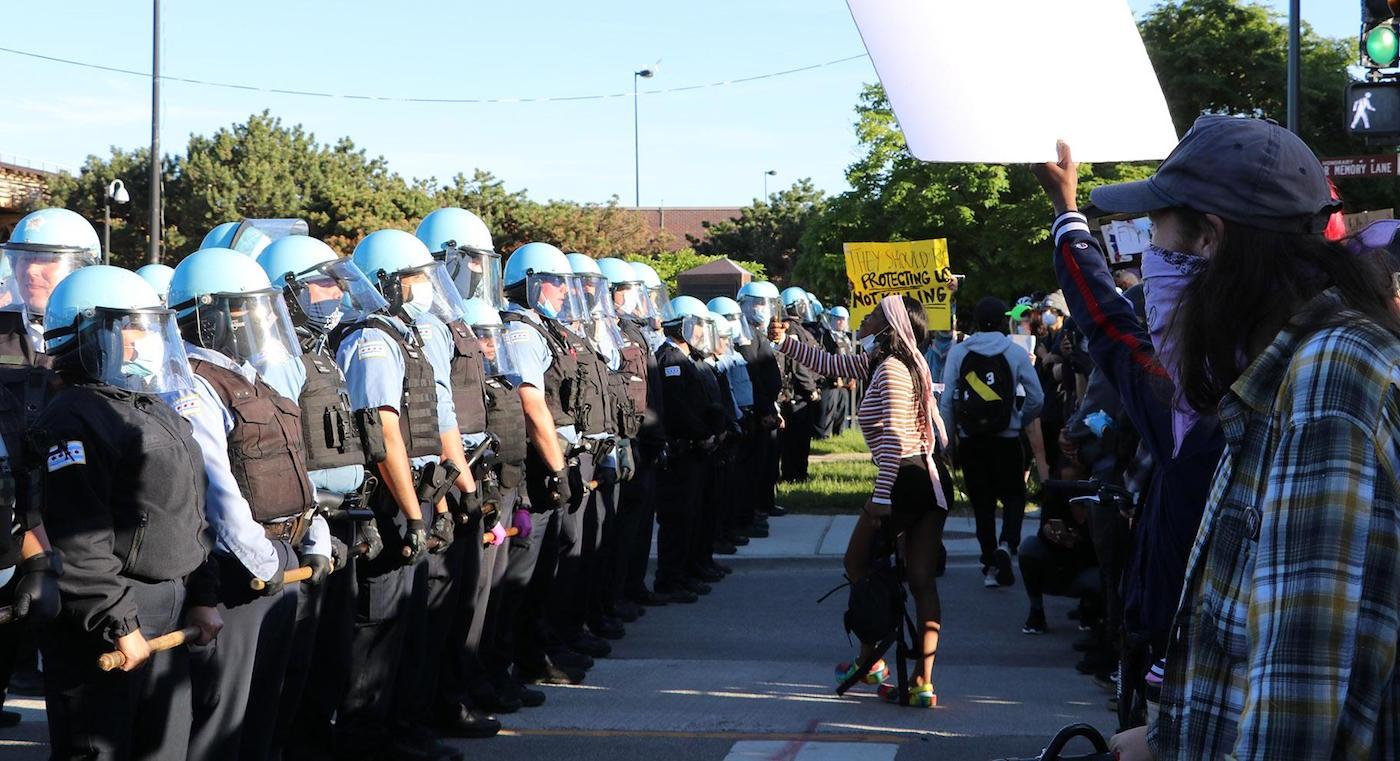 Protesters confront a line of police officers at State and 35th streets, about 3 miles south of the Loop, where police set up a blockade. (Evan Garcia / WTTW News)