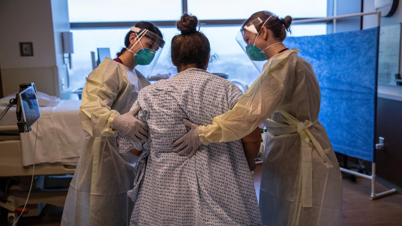 Hospital workers help COVID-19 patient and mother Zully to take her first steps after being removed from a ventilator at a Stamford Hospital ICU on April 24, 2020 in Stamford, Connecticut. Photo: John Moore/Getty Images
