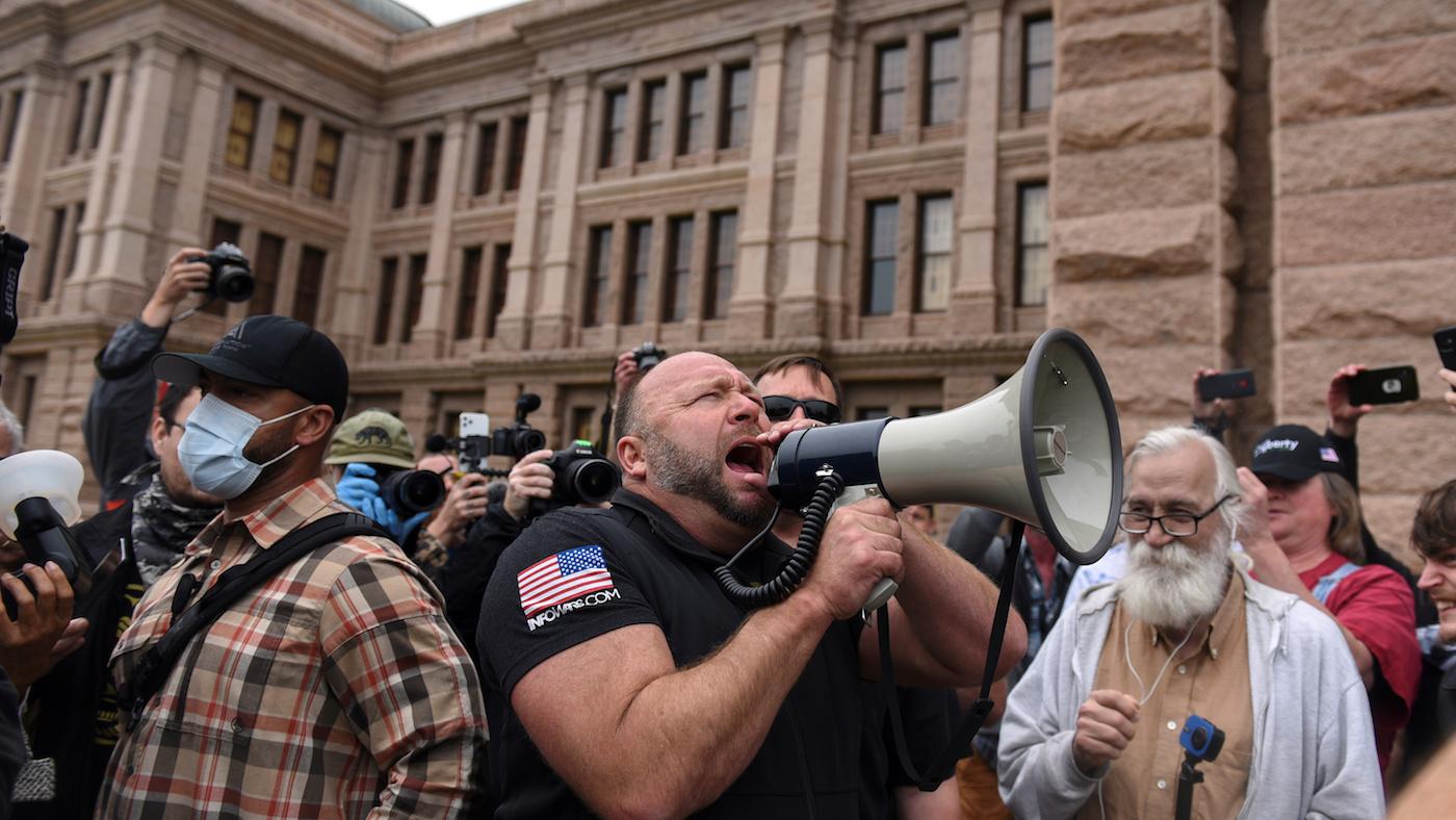 Alex Jones screams into a megaphone as protesters against the state's extended stay-at-home order to help slow the spread of the coronavirus disease (COVID-19) demonstrate at the Capitol building in Austin, Texas, U.S., April 18, 2020. Photo: REUTERS/Callaghan O’Hare