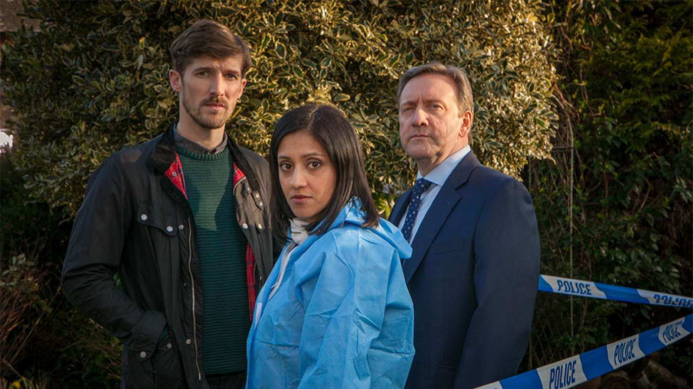 Gwilym Lee as DS Charlie Nelson, Manjinder Virk as Dr. Kam Karimore, and Neil Dudgeon as DCI John Barnaby in 'Midsomer Murders'
