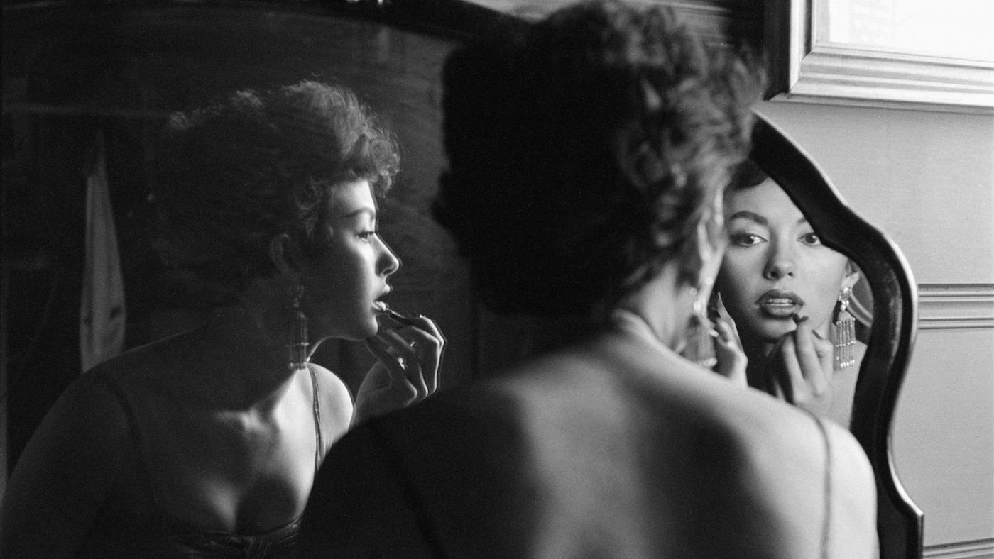 Rita Moreno Putting On Lipstick In Mirror, 1954. Photo: Getty Images